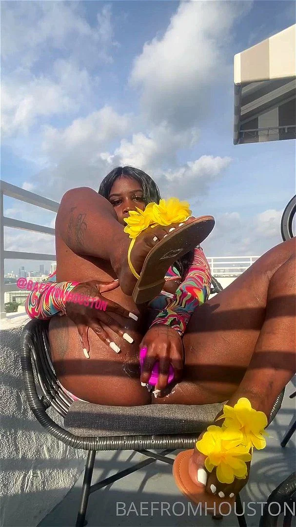 Ebony dildos her pussy on the terrace and squirts