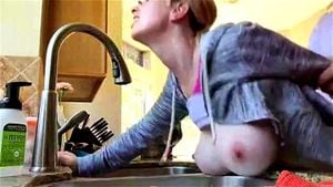 mature bent over the sink in the kitchen