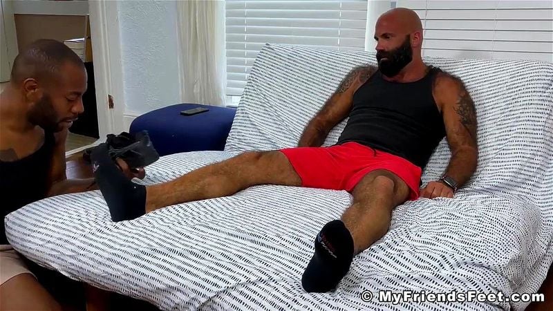 Hairy bearded stud has his feet sucked by a black gay dude