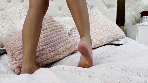 Hot girl plays on her bed with her feet