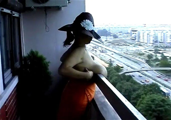 Busty wife strips nude on balcony