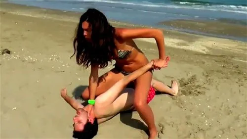 Babe fights and dominates guy on the beach