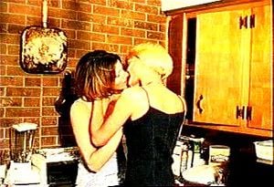 two girls kissing in the kitchen